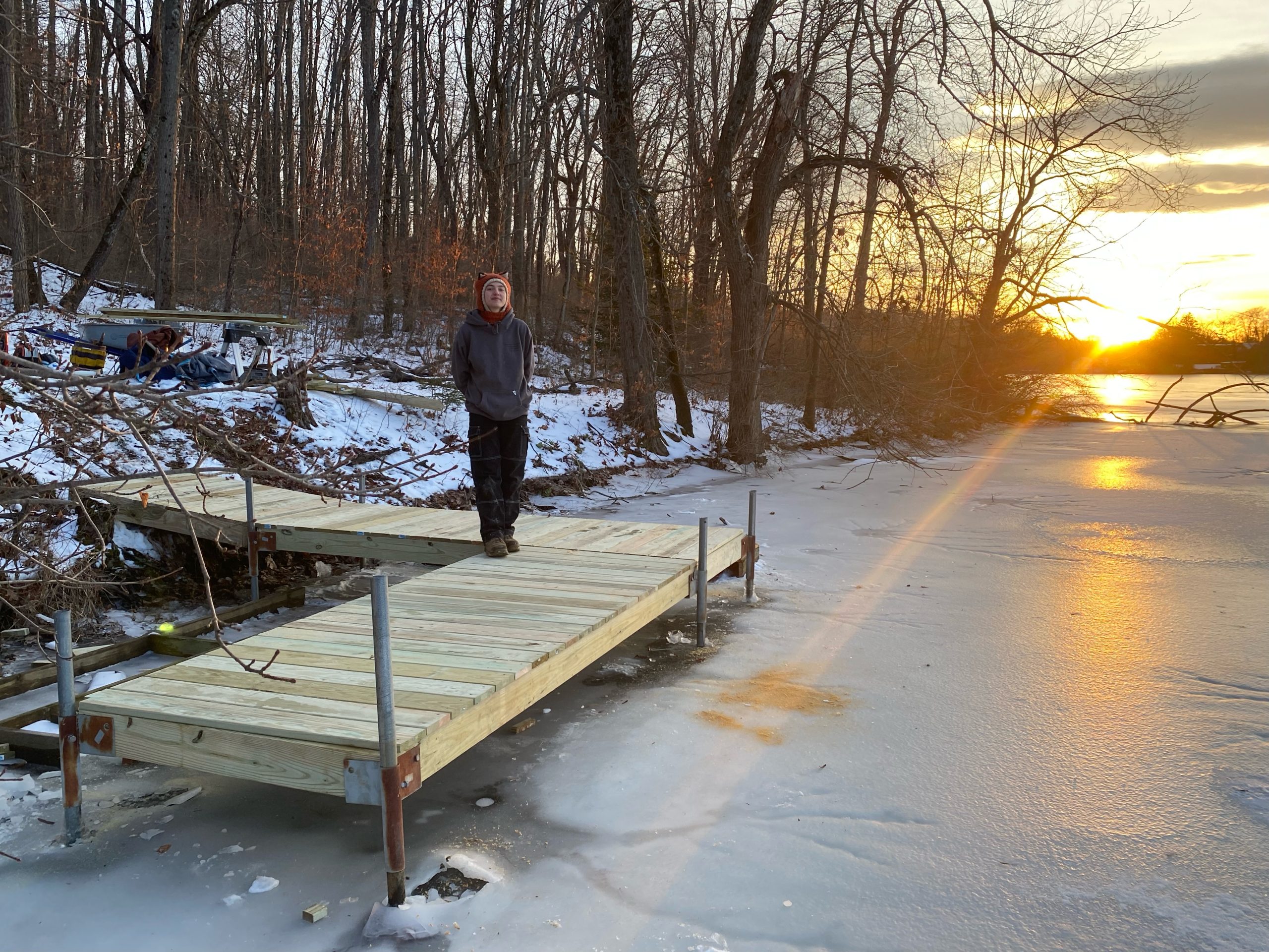 Lily Hindes standing on the rebuilt Summit Lake dock at sunset.