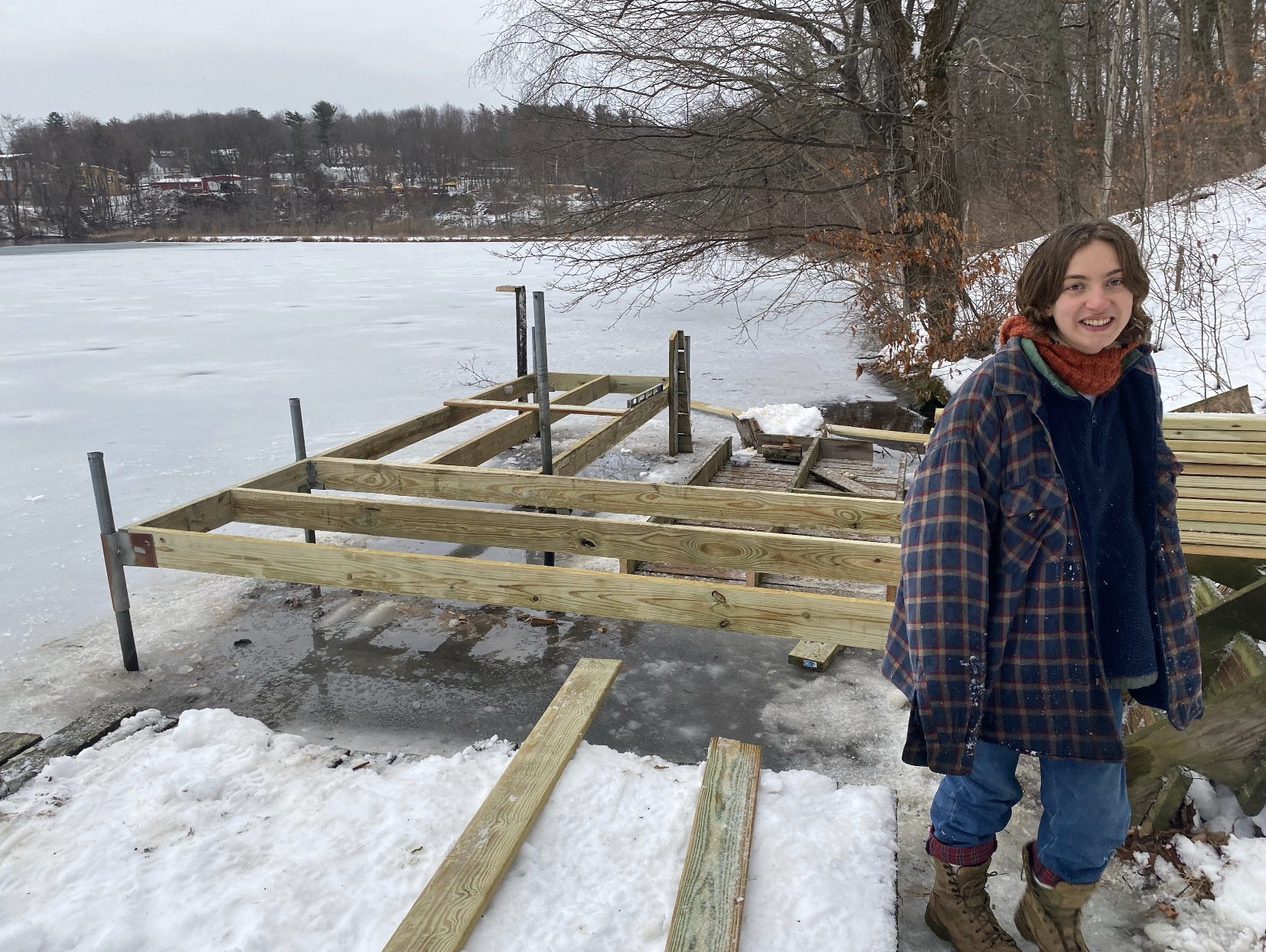 Lili Hindes standing in front of the rebuilt frame of the Summit Lake dock.