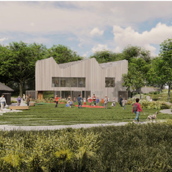 Modern building surrounded by greenery with people walking around.